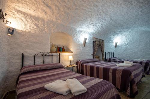 En eller flere senge i et værelse på Alojamiento Cuevas Victoria