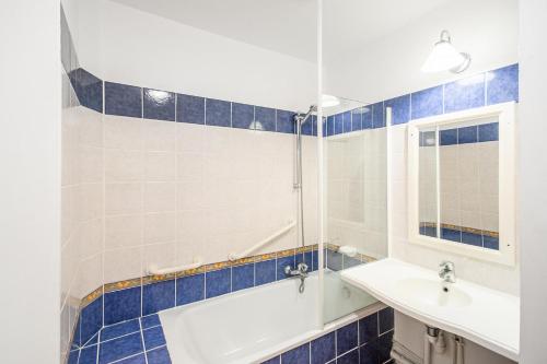 une salle de bain avec une baignoire, un lavabo et un miroir dans l'établissement Résidence Le Hameau de la Pinède - maeva Home - Studio 5 Personnes climatisé - Sélection MAE-0844, à Hyères