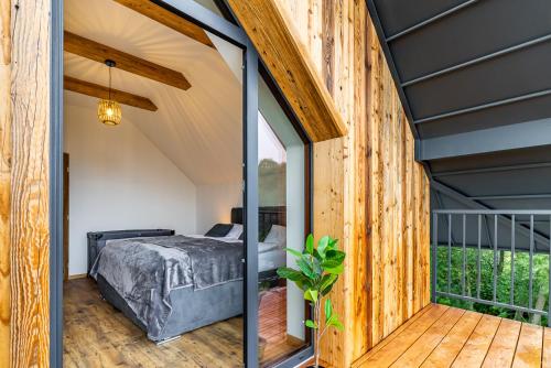 a room with a bed and a balcony at Chata Wellness Liptov in Ižipovce