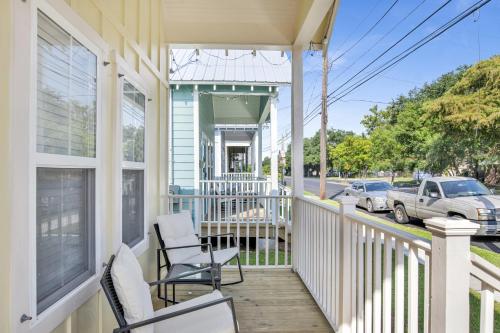 a porch of a house with two chairs and a car at Newly Built Cottage in Downtown Mobile, Walkable! in Mobile