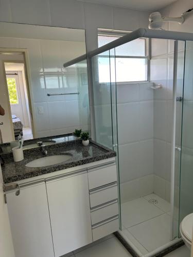 ein Badezimmer mit Glasdusche und Waschbecken in der Unterkunft Flat - Condomínio Brisa da Serra - Gravatá in Gravatá