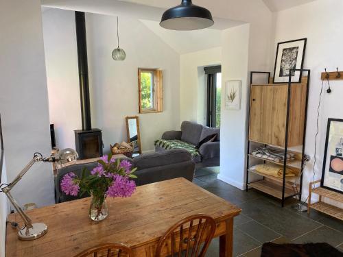 una sala de estar con una mesa y un sofá en Polly's Barn, Penrhyn, en Newport