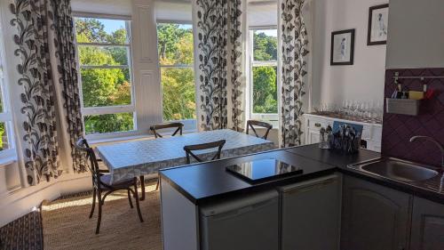 a kitchen with a sink and a table with chairs at Clarence House Apartments in Ventnor