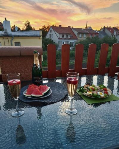 einen Tisch mit einer Flasche Champagner und zwei Gläsern in der Unterkunft Penzion Flóra in Žatec