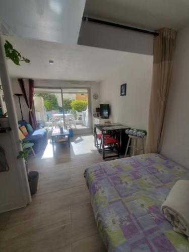 une chambre avec un lit et un salon dans l'établissement Appartement studio bord de mer, au Cap d'Agde
