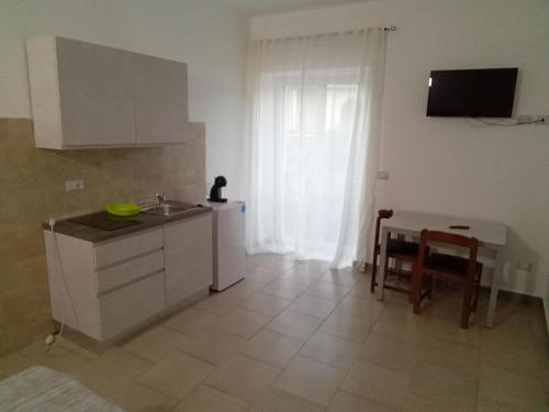 a kitchen with a sink and a table and a window at Affittacamere dragone in Cimitile