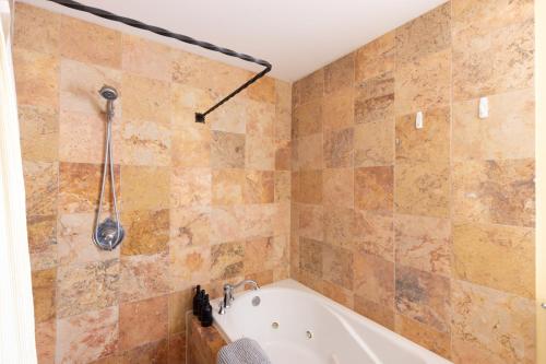 a bathroom with a tub and a shower at Casa Blanca Inn and Suites in Farmington