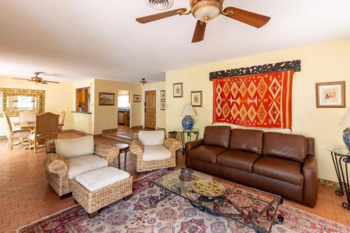 a living room with a couch and chairs and a ceiling fan at Casa Blanca Inn and Suites in Farmington