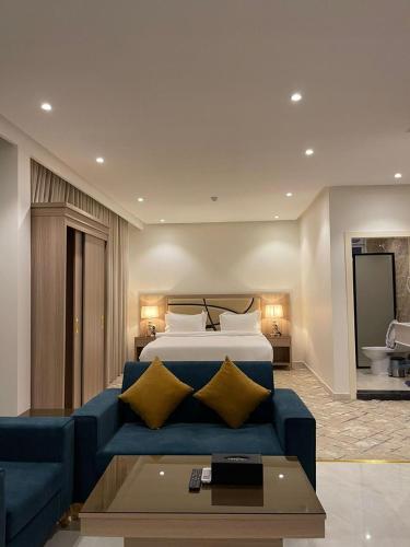 a hotel room with a bed and a blue couch at ليبرا سويتس - Libra Suites in Khamis Mushayt