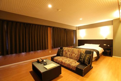 a hotel room with a bed and a couch at Town Hotel 41 in Kanazawa