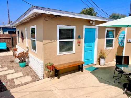 a small house with a blue door and a bench at Cozy Beach Cottage with Bicycles in San Diego