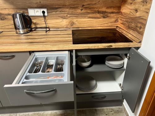 a kitchen with an open drawer with plates and utensils at Apartmán na náměstí II in Králíky