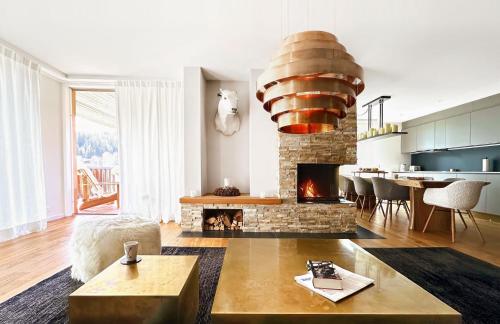 a living room with a fireplace and a table at Ski-in Ski-out-Apartment Mountain Nest Parpan in Parpan