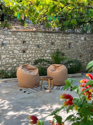 a patio with two chairs and a table and a wall at Nika's Guest House in Berat
