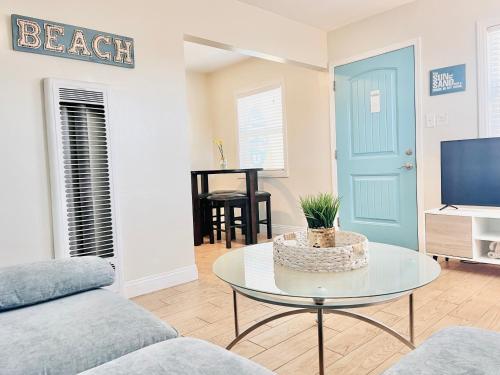 a living room with a couch and a table and a tv at Cozy Beach Cottage with Bicycles in San Diego