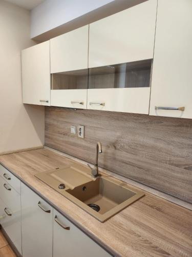 a kitchen with a sink and white cabinets at Penzión Daniel in Ilava