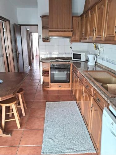 a kitchen with wooden cabinets and a counter top at Cantinho do Liceu in Figueira da Foz