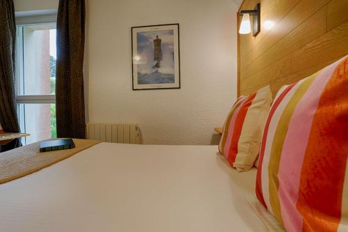 a bedroom with a large white bed with a window at Hotel Le Branhoc - Brit Hotel Auray in Auray