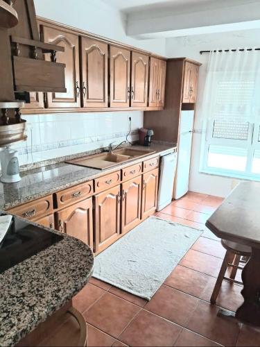 a kitchen with wooden cabinets and a tile floor at Cantinho do Liceu in Figueira da Foz