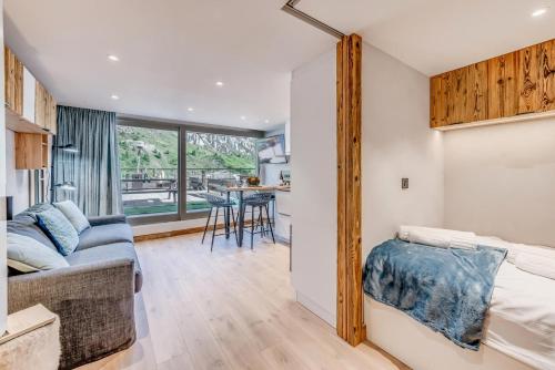 une chambre avec un lit et un salon dans l'établissement Résidence Palafour - Studio chaleureux, terrasse vue lac MAE-3398, à Tignes