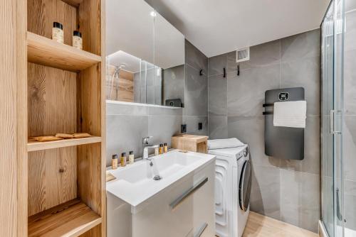 une salle de bain avec un lavabo et une machine à laver dans l'établissement Résidence Palafour - Studio chaleureux, terrasse vue lac MAE-3398, à Tignes