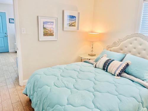 a bedroom with a bed with a blue comforter at Cozy Beach Cottage with Bicycles in San Diego