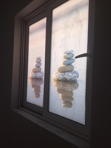 a stack of rocks sitting in a window at Seashell Apartment in Artemida