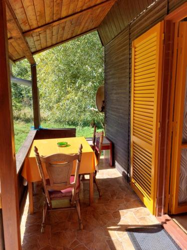 a dining room with a table and chairs on a patio at Rekreační středisko ROJANA in Svratka