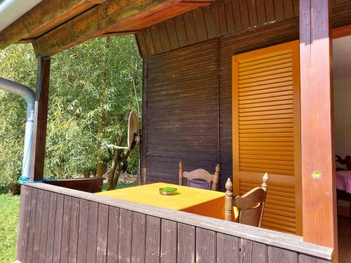 a patio with a yellow table and chairs on a house at Rekreační středisko ROJANA in Svratka