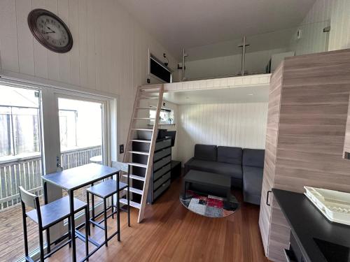 a small apartment with a couch and a table and a kitchen at Centralt belägen Attefalls stuga in Falkenberg