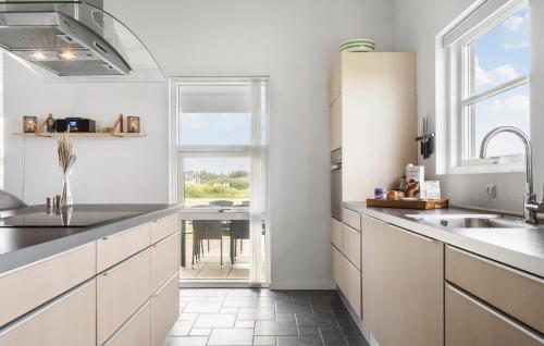 a kitchen with white cabinets and a sink and a window at Lovely Home In Tarm With Wifi in Tarm
