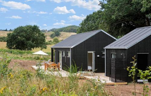 a black shed with a table and an umbrella at 4 Bedroom Nice Home In Ebeltoft in Ebeltoft