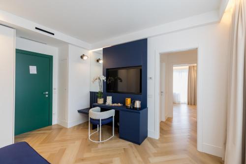 a living room with a blue desk and a tv at Grand Hotel Cesare Augusto in Sorrento
