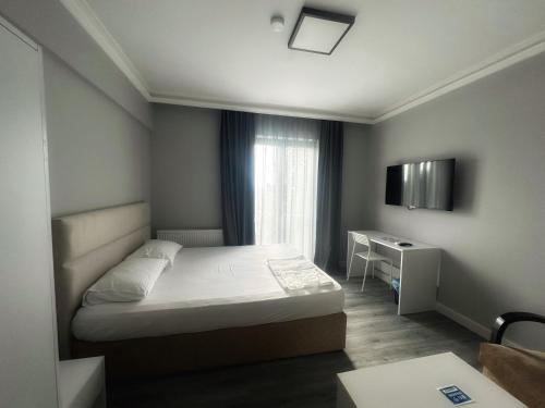 ASLAN AİRPORT Hotel في Arnavutköy: غرفة نوم صغيرة بها سرير ومكتب