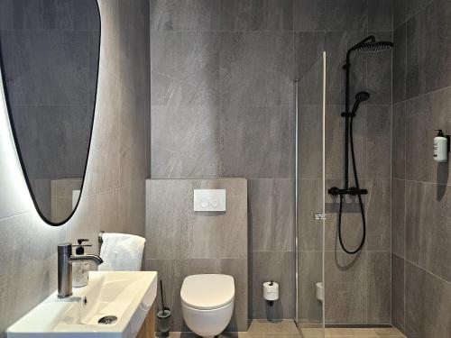 a bathroom with a shower and a toilet and a sink at Hótel Laugarvatn in Laugarvatn