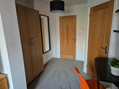 a hallway with wooden doors and a table and chairs at Carolines rooms in Cherry Hinton