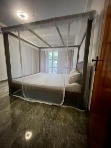 a bedroom with a canopy bed with a window at Eleven Thalalla in Talalla South