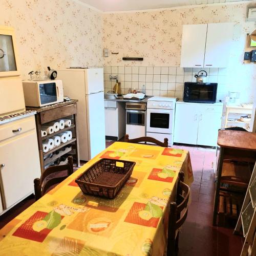 une cuisine avec une table et une cuisine avec des appareils électroménagers blancs dans l'établissement La Barkalo, à Autet