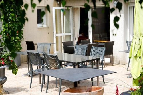 a group of tables and chairs on a patio at Hotel Le Branhoc - Brit Hotel Auray in Auray