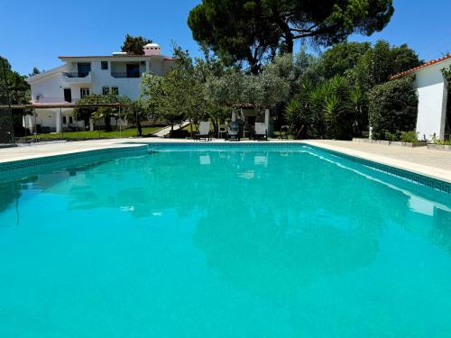 a large blue swimming pool in front of a house at Portuguese Luxury Villa in Setúbal
