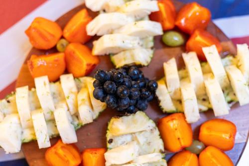 a plate of food with cheese and fruits and vegetables at Hotel Britannia in Penedo