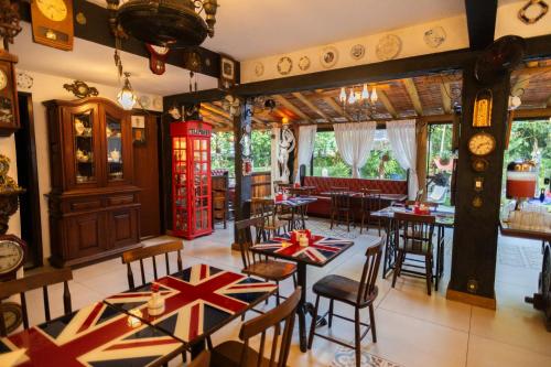 a restaurant with tables and chairs with british flags on them at Hotel Britannia in Penedo