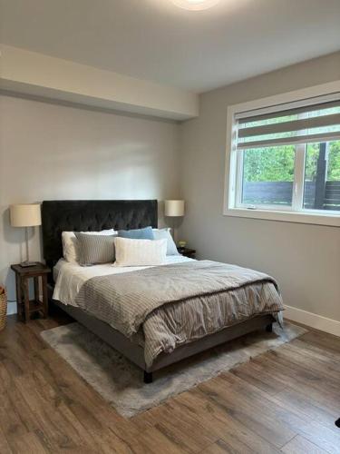 a bedroom with a large bed and a window at Executive 1 Bedroom Lakeview Retreat in Shawnigan Lake