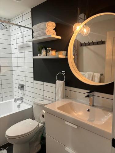 a bathroom with a sink and a toilet and a mirror at Executive 1 Bedroom Lakeview Retreat in Shawnigan Lake