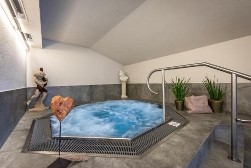 a jacuzzi tub in the middle of a room at Vitaurina Royal Hotel in Molini di Tures