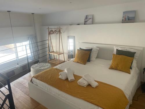 une chambre avec un grand lit blanc avec deux serviettes dessus dans l'établissement le roche-terrail, à Marseille