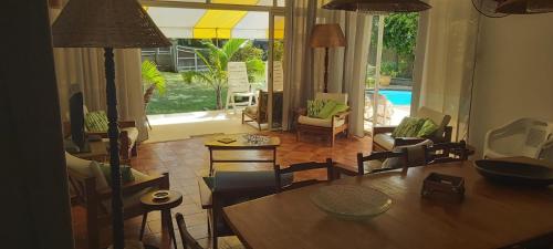 a living room with a table and chairs and a pool at MonKAZ Résidence 3 chambres, Pereybère in Bain Boeuf