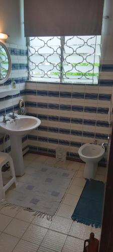 a bathroom with two sinks and a toilet and a window at MonKAZ Résidence 3 chambres, Pereybère in Bain Boeuf