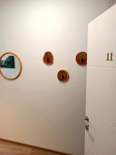 a white wall with three wooden plates on it at Apartments Romantic and Family Room Zemlinski in Payerbach