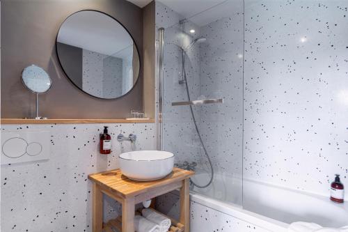 a bathroom with a sink and a shower and a mirror at Eden Park Hotel Restaurant in Pont-lʼÉvêque